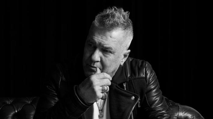 Jimmy Barnes in black and white with a composed pose advertising for his tour near motel 429